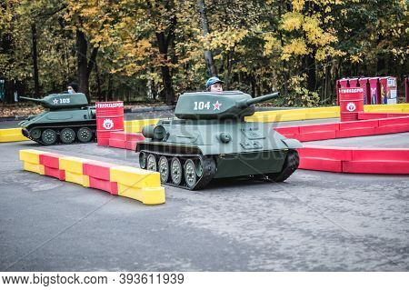 Russia, Moscow - October 10, 2020: Young Boy Drives Toy Tank. Children Attraction In Vdnkh Park In M