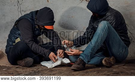 Two Shabby Men Preparing Drug Injection In Slums.