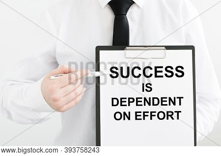 Card With Text Success Is Dependent On Effort In The Hands Of A Man On A Light Background