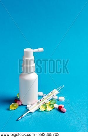 White Bottle In The Form Of A Spray With A Medicine For The Throat And Medicine In The Form Of Pills
