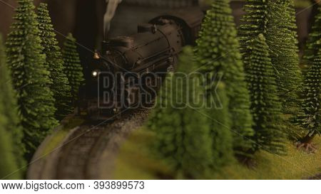 Retro Steam Lokomotive Amoung Trees. Miniature Train Model On A Railroad.