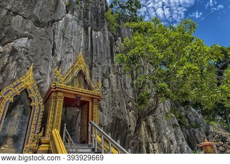 Thailand, Phetchaburi 19.07.2019 View Of Wat Tham Khao Yoi Cave, Buddhist Temple With Green Tree And