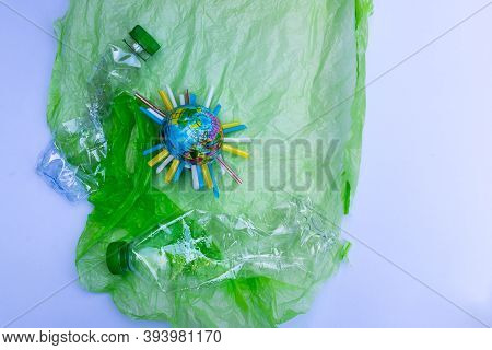 Global Warming Pollution. Blue Plastic Globe Is Inserted With Piece Of Plastic Tube In Middle. World