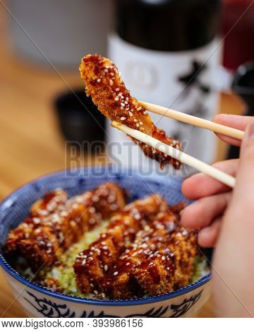 Eating Japanese Fried Chicken With Katsudon Rice In A Traditional Blue Bowl