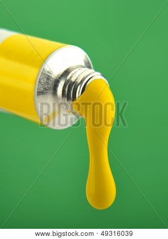 Макро желтой краской, сочится из трубки краска