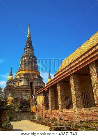Ancient structure and Buddha temple with old pagodas against blue sky at Ayutthaya