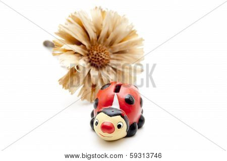 Ceramic beetle with straw flower