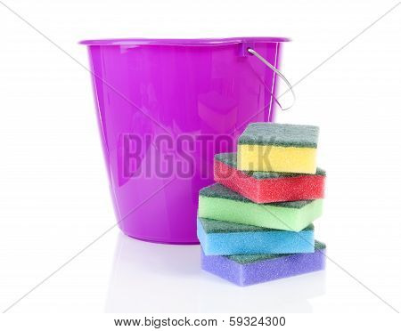 Pile Of Colorful Sponge Scourer And Pink Bucket Over White Background
