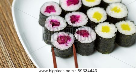 Selecting Pickled Sushi From Plate With Chop Sticks