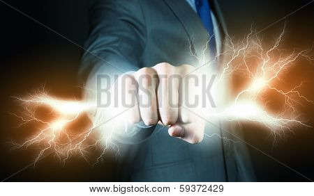 Businessman holding lightning in fist. Power and control