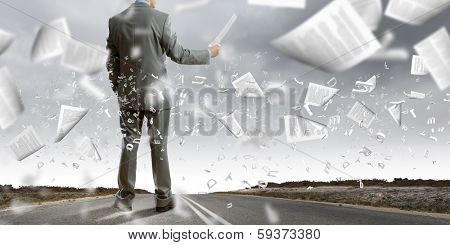 Back view of businessman reading documents in hand