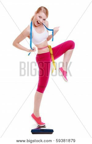 Woman With Measure Tape On Scale Celebrating Weightloss