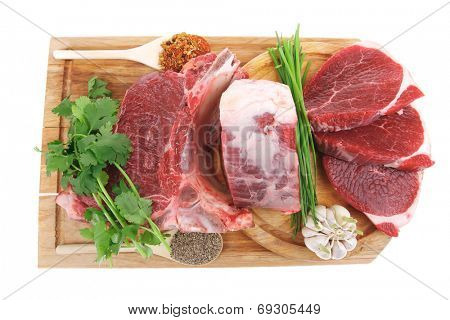 butchery : fresh raw beef lamb big rib and fillet ready to cooking with green stuff on wooden plate isolated over white background