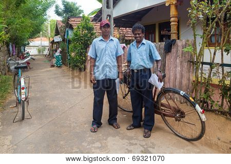 WELIGAMA, SRI LANKA - MARCH 8, 2014: Two postmen delivering post to local people. Sri Lanka Posts has been in existence for more than 209 years and employs more than 17,000 employees.
