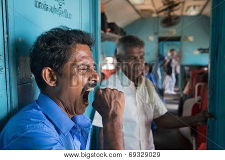 HIKKADUWA, SRI LANKA - MARCH 12, 2014: Local man yawning in train. Trains are very cheap and poorly maintained but it's the best option to witness a bit of everyday local life.