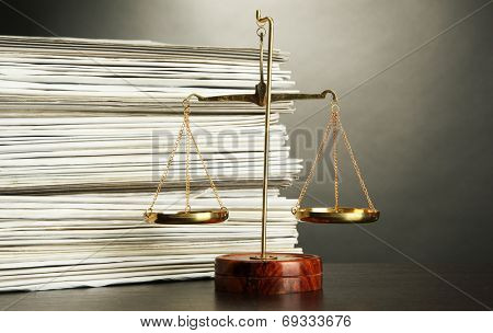 Gold scales of justice and folders on grey background