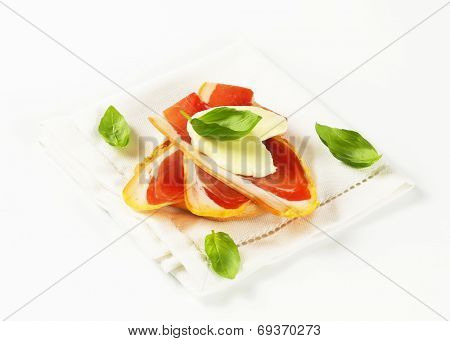 Slices of prosciutto and mozzarella on Friselle bread