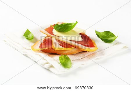 Slices of prosciutto and mozzarella on Friselle bread