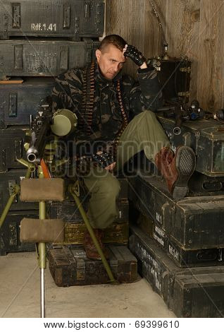 Thoughtful armed soldier sits