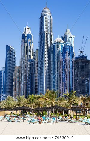 DUBAI UAE - November 28: Tourists relax on city beach November 28 2014 in Dubai. More than 10 million people visit the city every year.