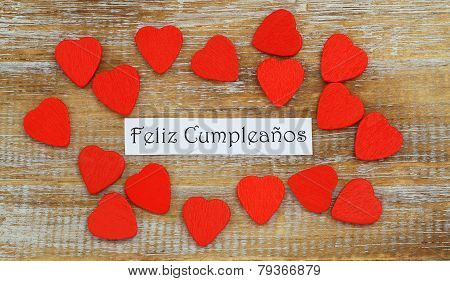 Feliz Cumpleanos (which means Happy Birthday in Spanish) with little red wooden hearts