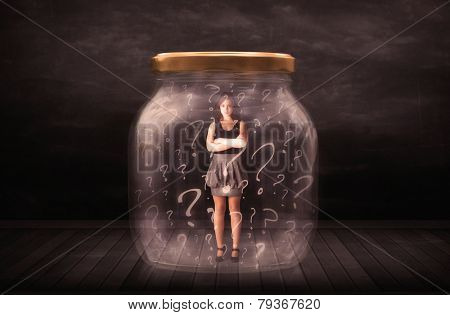 Businesswoman locked into a jar with question marks concept on background