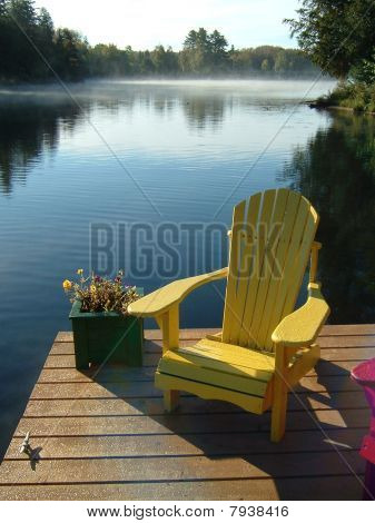 Žluté křeslo Muskoka v doku na jezeře