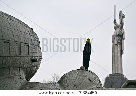 Monumental Statue Of The Motherland And Vintage Aircraft In The Foreground