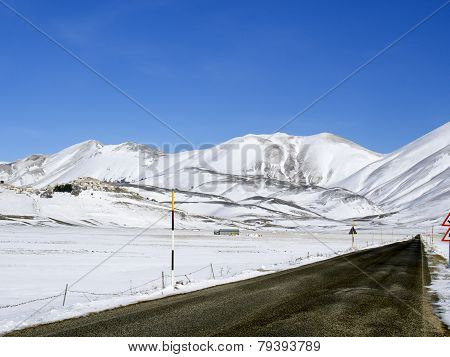 Asphalt Straight Road Along  Plateau Of Castelluccio Of Norcia In Winter,