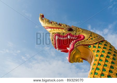 serpent king or king of naga statue in thai temple on blue sky background