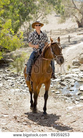 Instructor Or Cattleman Riding Horse In Sunglasses, Cowboy Hat And Rider Boots