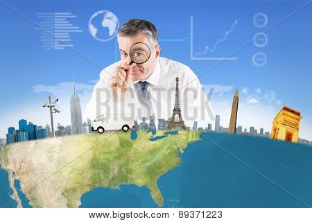 Focused businessman with magnifying glasses against bright blue sky