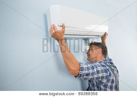 Male Technician Fixing Air Conditioner