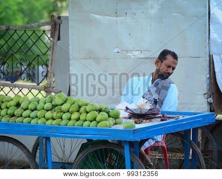 A Man Sells Fruits From A Stall In Delhi