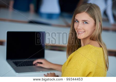 portrait of happy smilling student girl at tech classroom with laptop computer in background