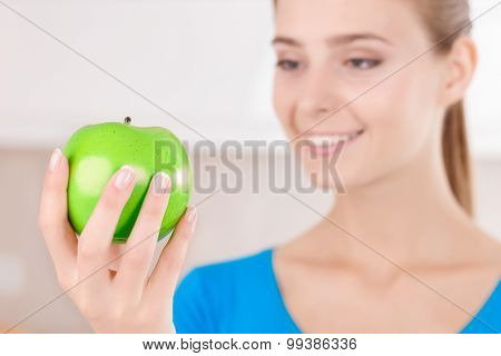 Delightful young woman holding apple
