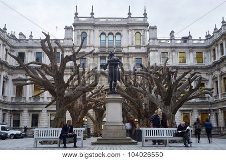 LONDON, UK - SEPTEMBER 23: Visitors appreciating Ai Wei Wei's installation 'Tree' in the forecourt of the Royal Academy of Arts. September 23, 2015 in London.