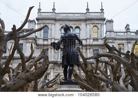 LONDON, UK - SEPTEMBER 23: Statue of Sir Joshua Reynolds amongst Ai Wei Wei's installation 'Tree' in the forecourt of the Royal Academy of Arts. September 23, 2015 in London.