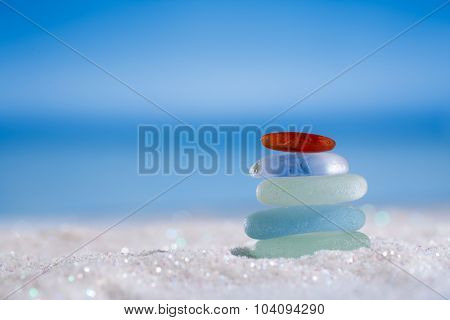 sea glass seaglass stone on glitter sand with ocean , beach and seascape, shallow dof