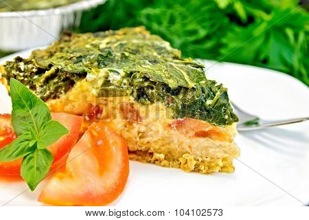 Pie celtic with spinach in dish on table