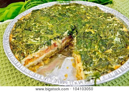 Pie celtic with spinach and tomatoes in form of foil on board