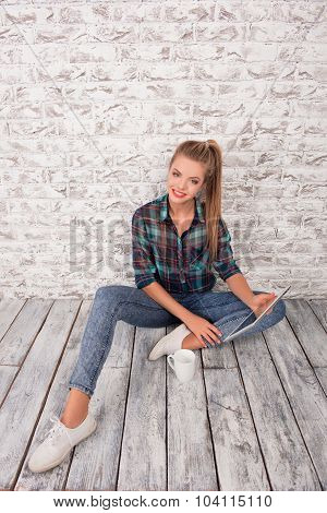 Good-looking Girl With Tablet And Cup Sitting On The Floar
