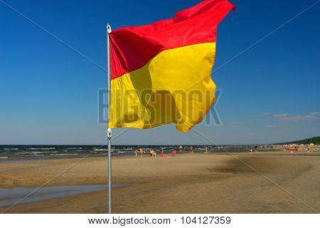 Red And Yellow Flag On The Beach Of The Baltic Sea