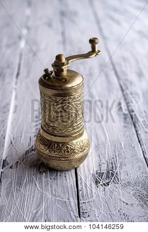 Vintage Still Life With Brass Pepper Mill Standing On The Wooden Background.