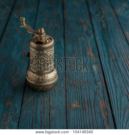 Vintage Still Life With Brass Pepper Mill Standing On The Wooden Background.