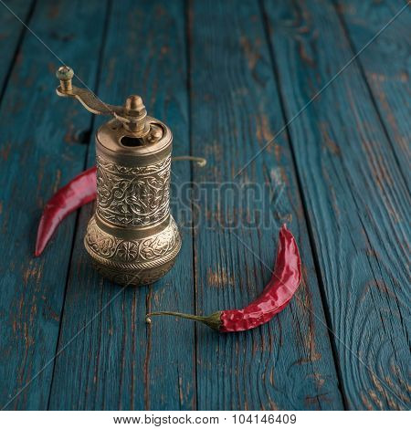 Mill For Pepper And Chili Peppers On A Wooden Table.