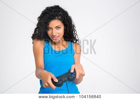 Portrait of a beautiful afro american woman playing in video game with joystick isolated on a white background