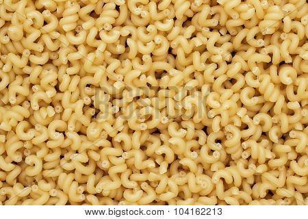 dry uncooked cavatappi pasta texture background