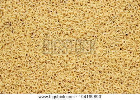 dry uncooked anelletti pasta texture background