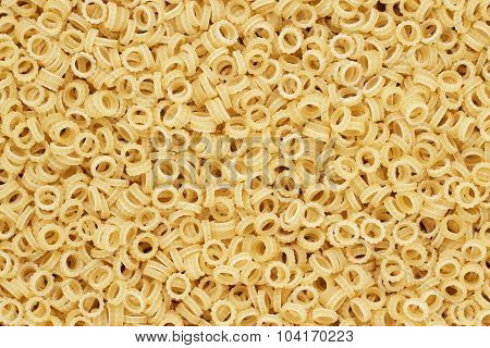 dry uncooked anelletti pasta texture background